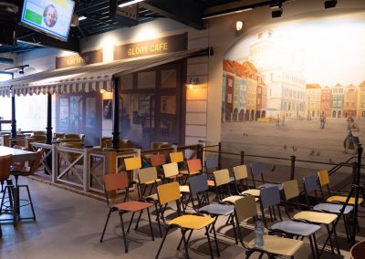 Muurbeschildering van plein met cafe en restaurant bij een bedrijf