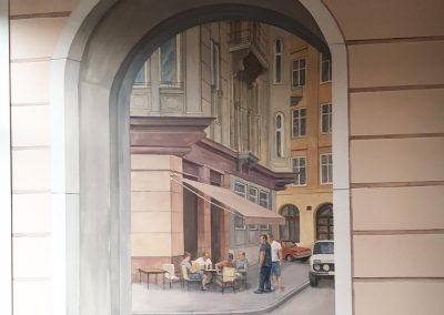 Muurschildering bij een cafe door een poort gezien